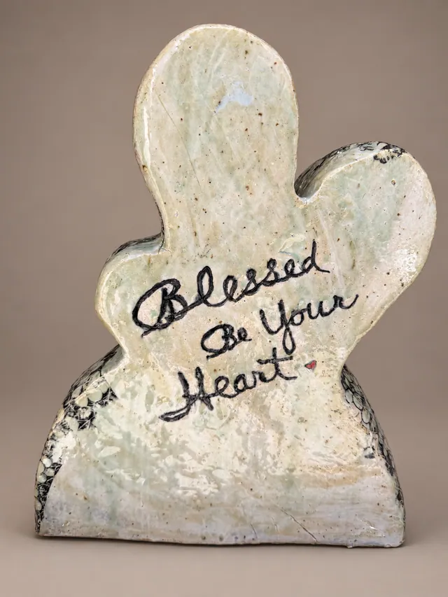 Figure-shaped slab inscribed "Blessed Be Your Heart"