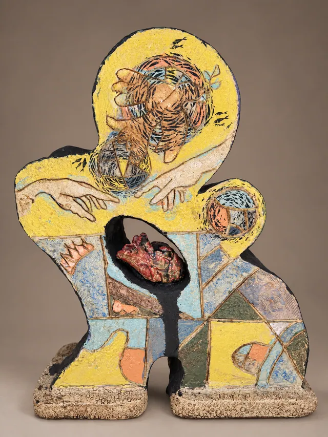 Yellow figure-shaped slab with patchwork panels and a heart in an open window