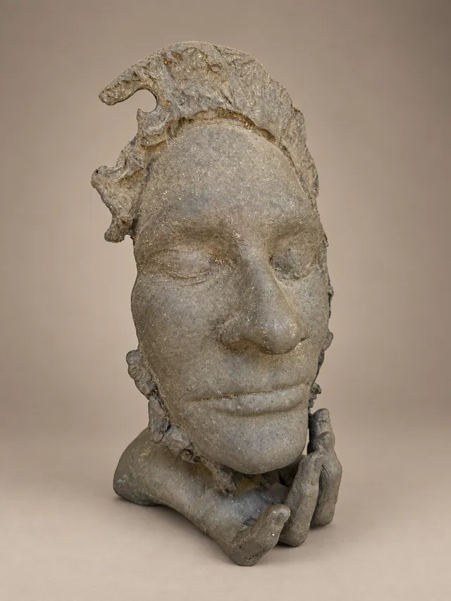 Stone-grey face resting on a hand