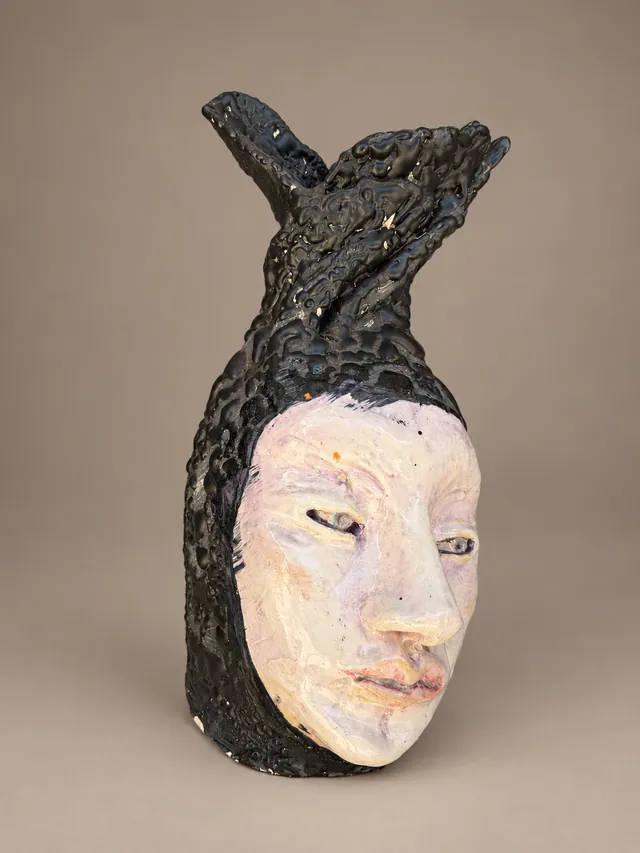 Pale face framed by black textured horns